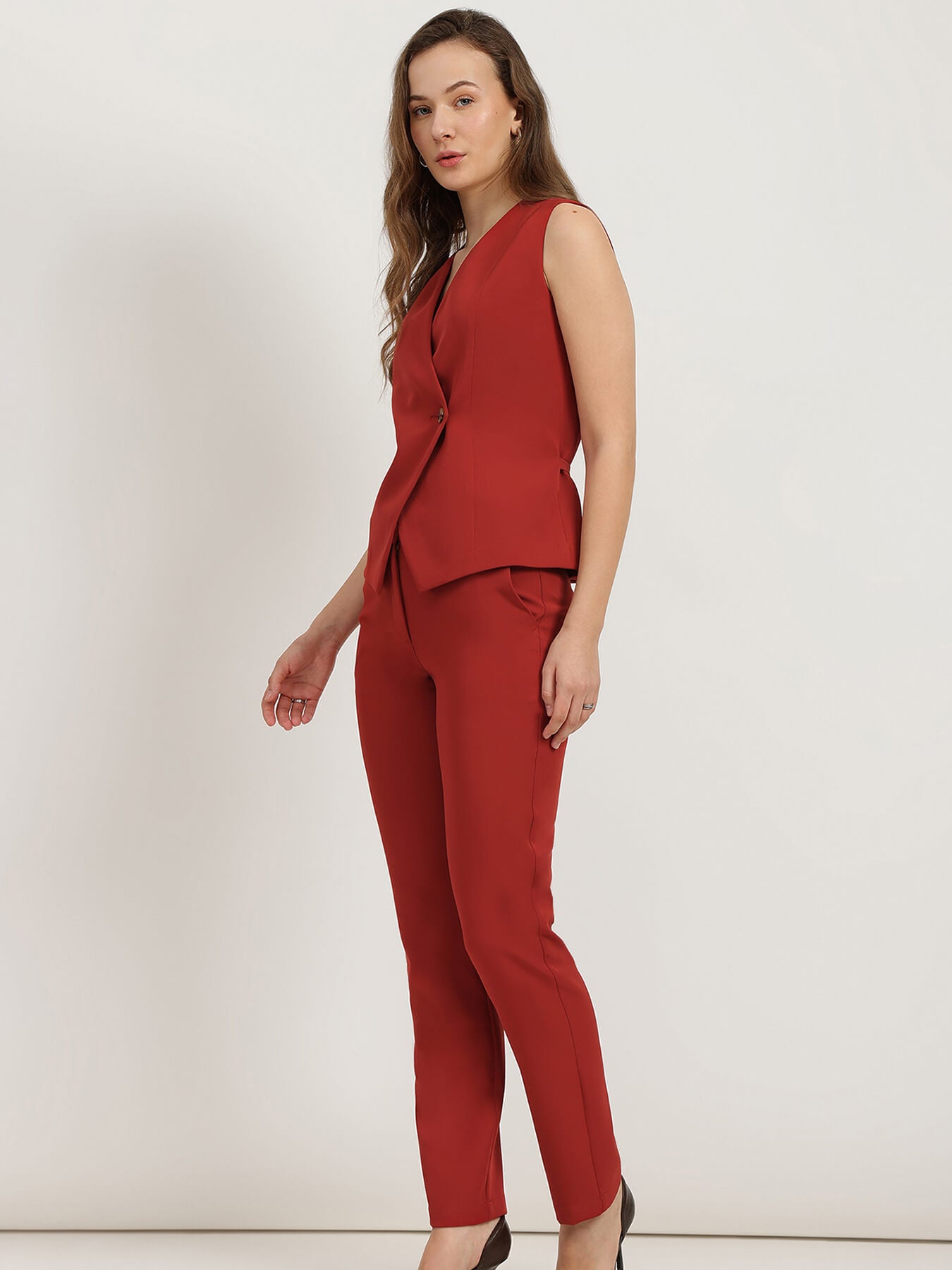 Woman wearing a red co-ord suit on a white background