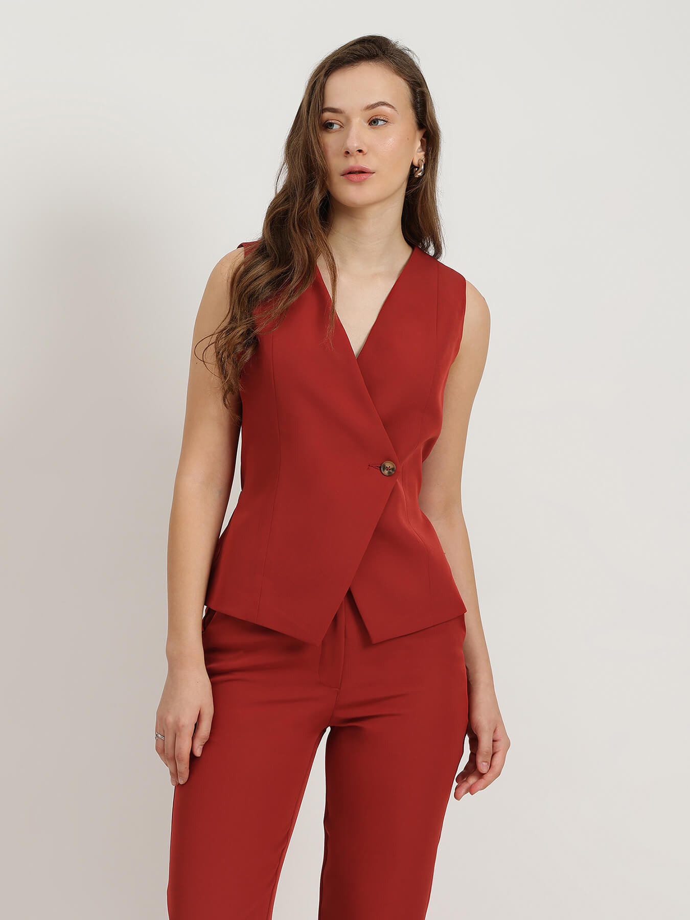Woman wearing a red co-ord suit on a white background