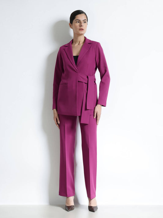 Woman wearing a magenta suit against a white background