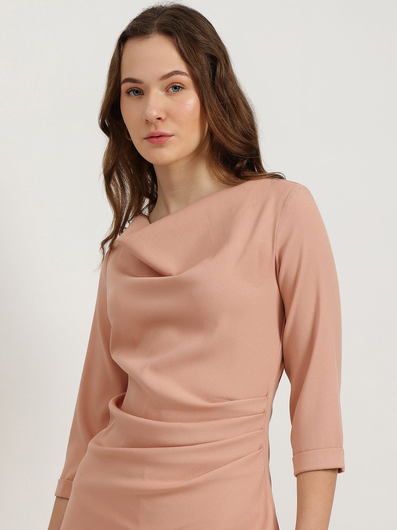 Woman wearing a pink dress against a plain background