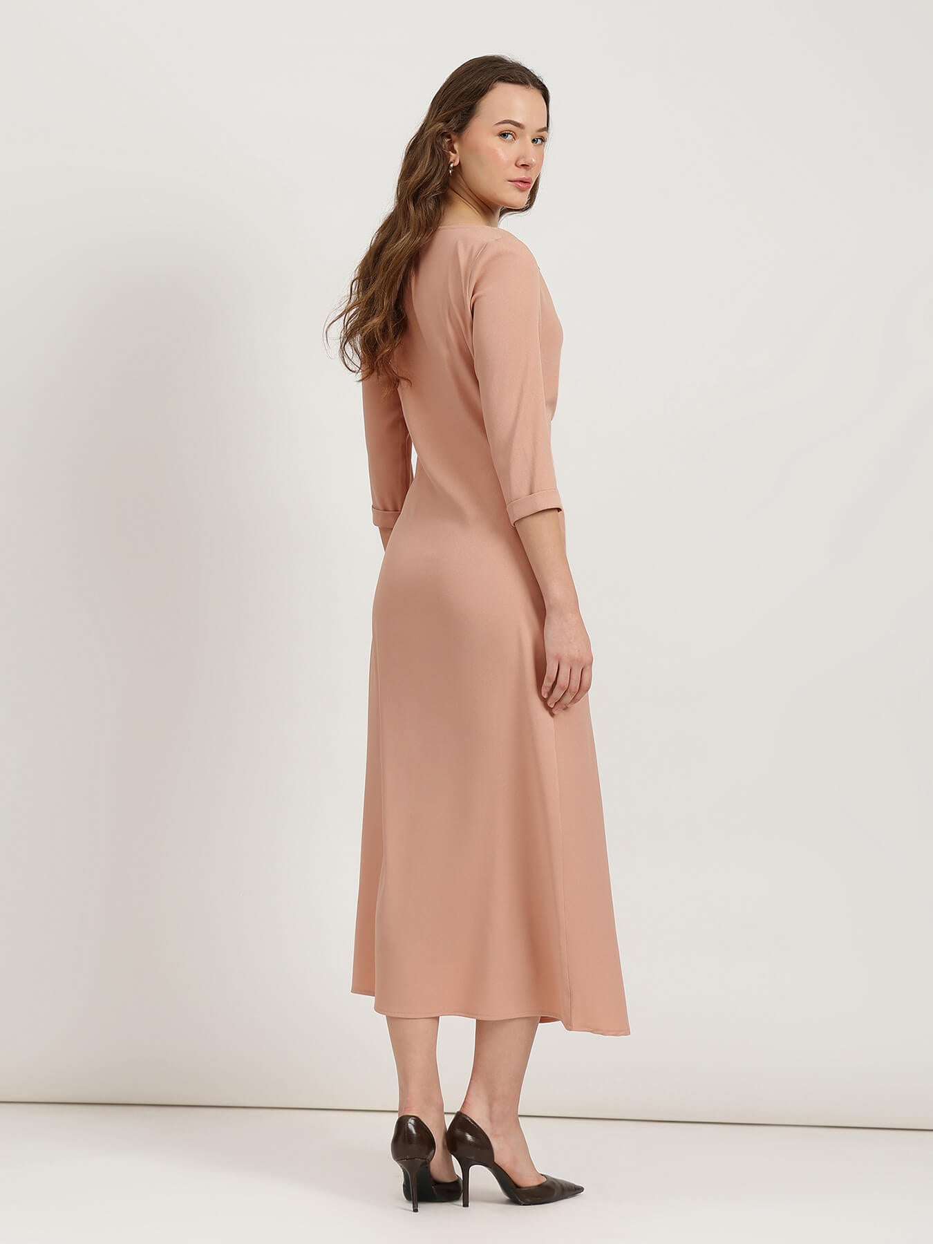 Woman wearing a beige dress on a white background