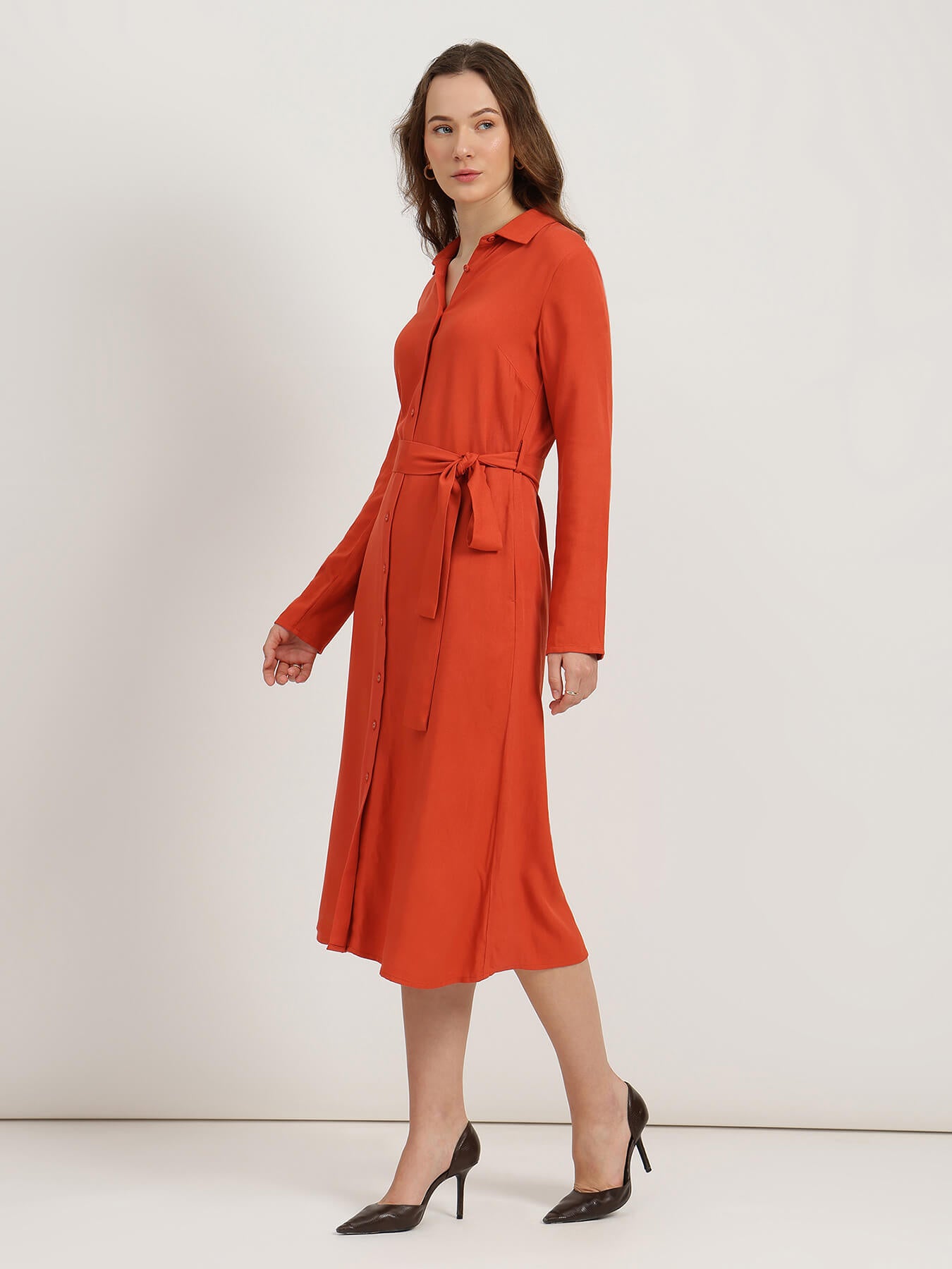 Woman wearing an orange dress against a white background