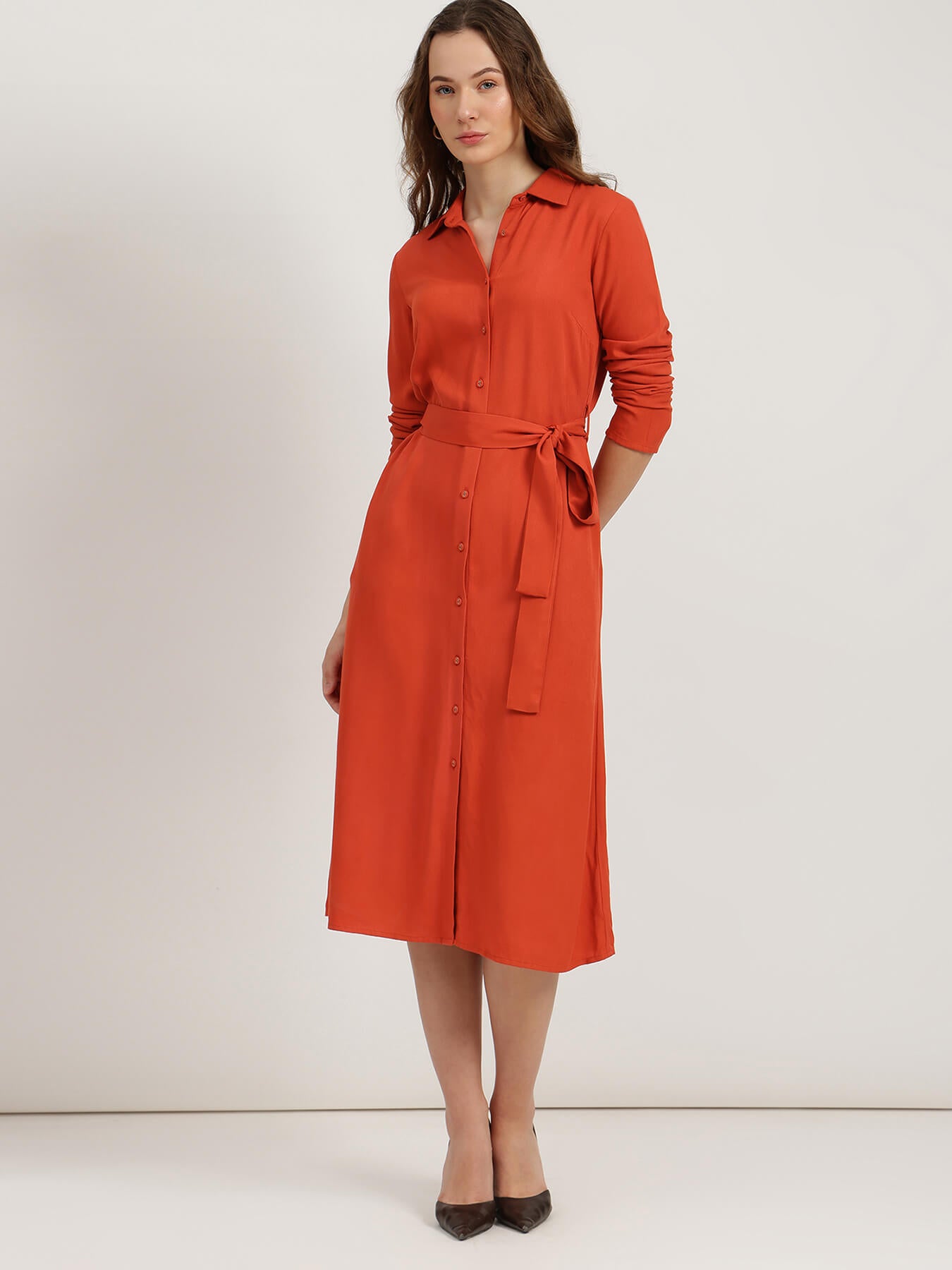 Woman wearing an orange dress against a white background