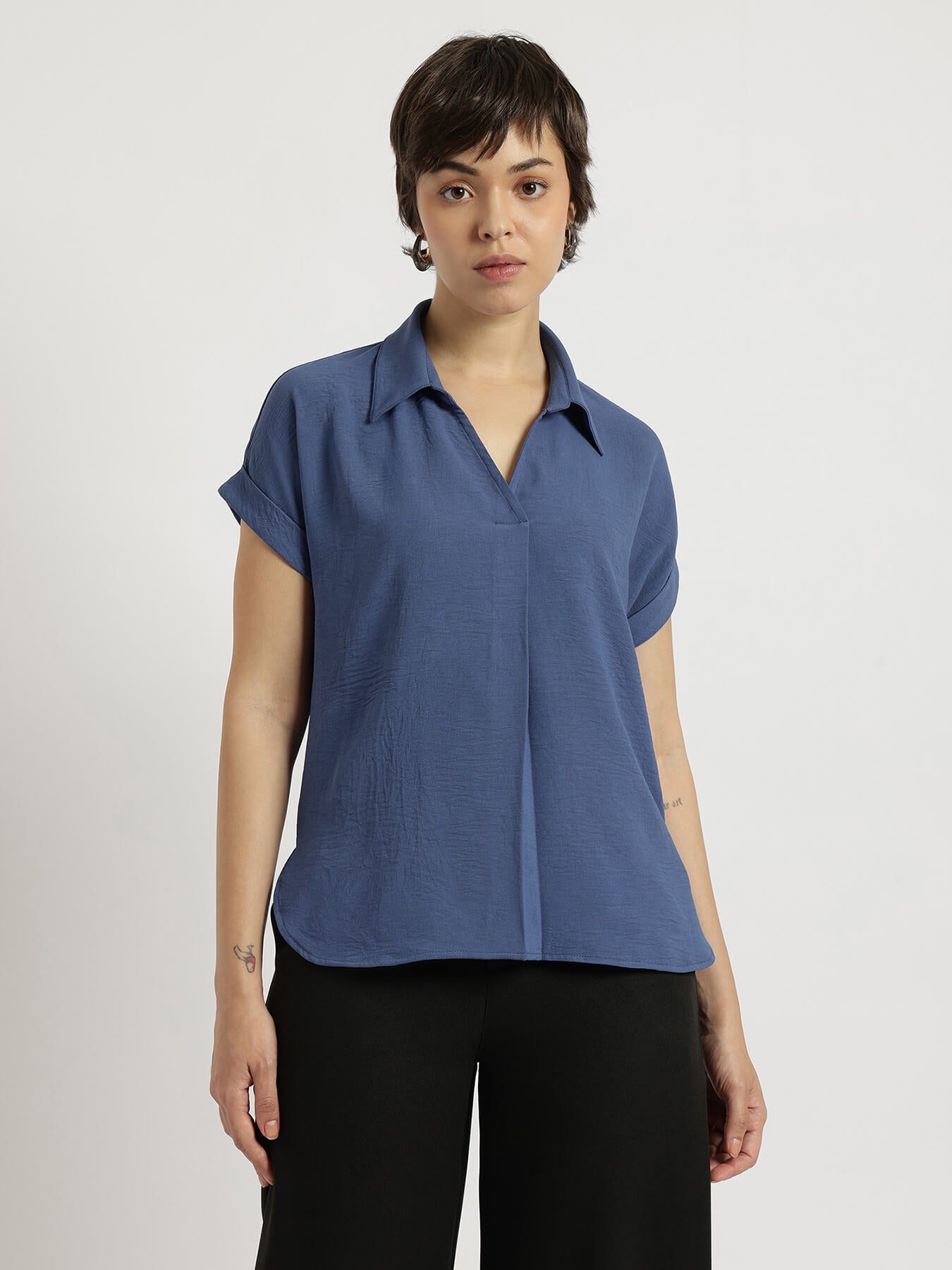 Person wearing a blue short-sleeve shirt against a white background