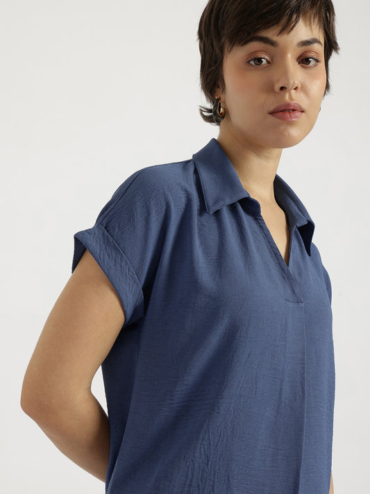 Woman wearing a blue shirt against a plain background