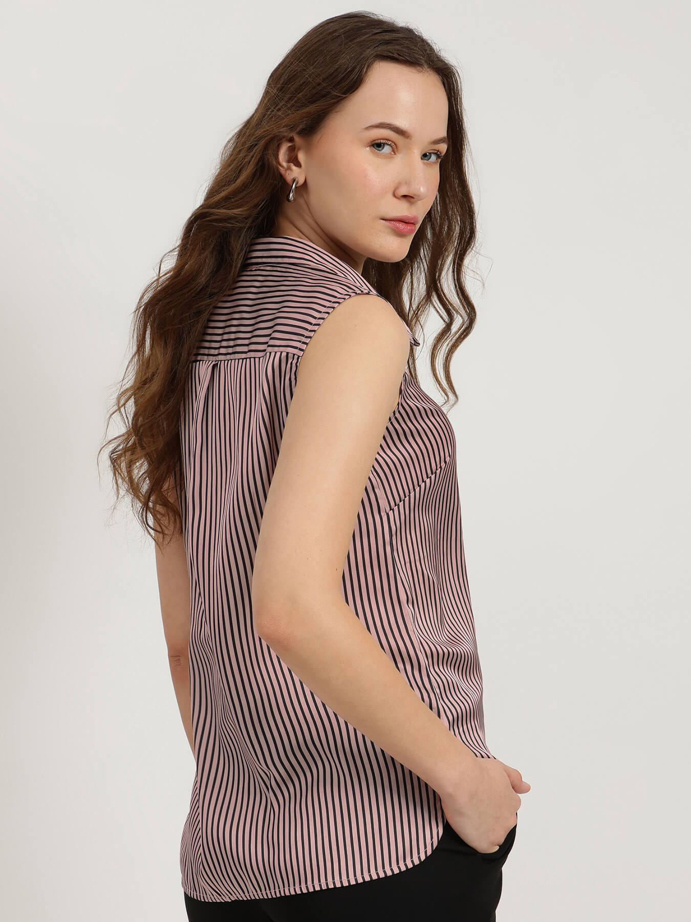 Woman wearing a striped shirt against a plain background