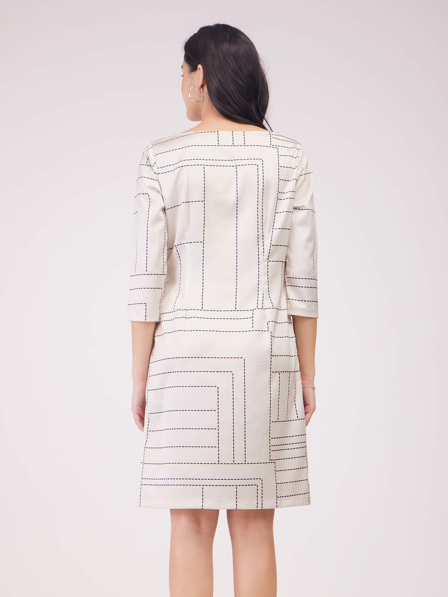 Woman wearing a patterned dress with 'FS Work' branding on a white background