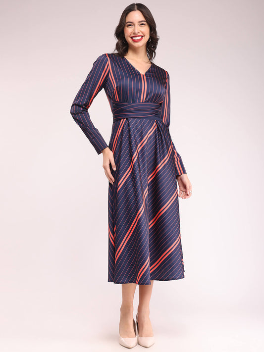 A model wearing a navy and red striped fit and flare dress with long sleeves, a V-neck, and a waist belt.