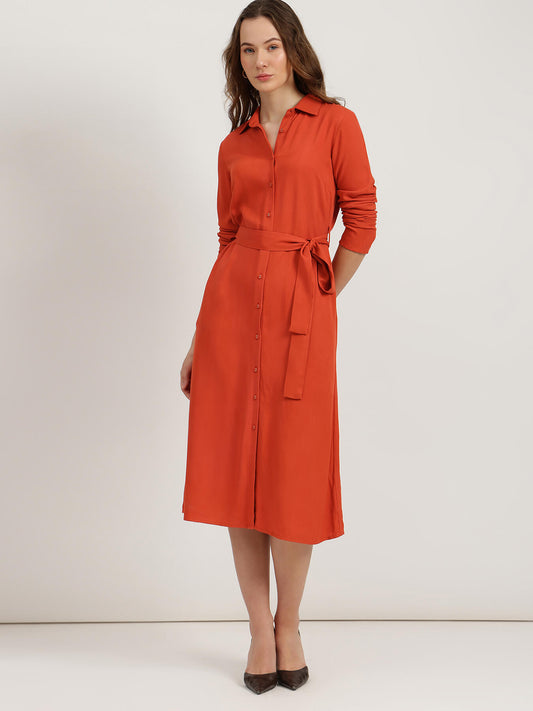 Woman wearing an orange dress against a white background