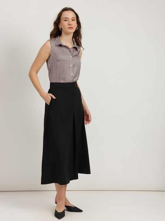 Woman wearing a sleeveless striped shirt and black skirt on a white background